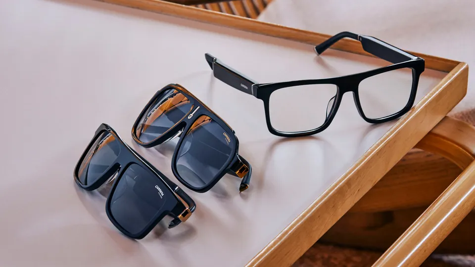 Three pairs of Carrera-branded Echo Frames on a pale tray with a wooden rim, two pairs of dark sunglasses and one pair of clear-lens black frames