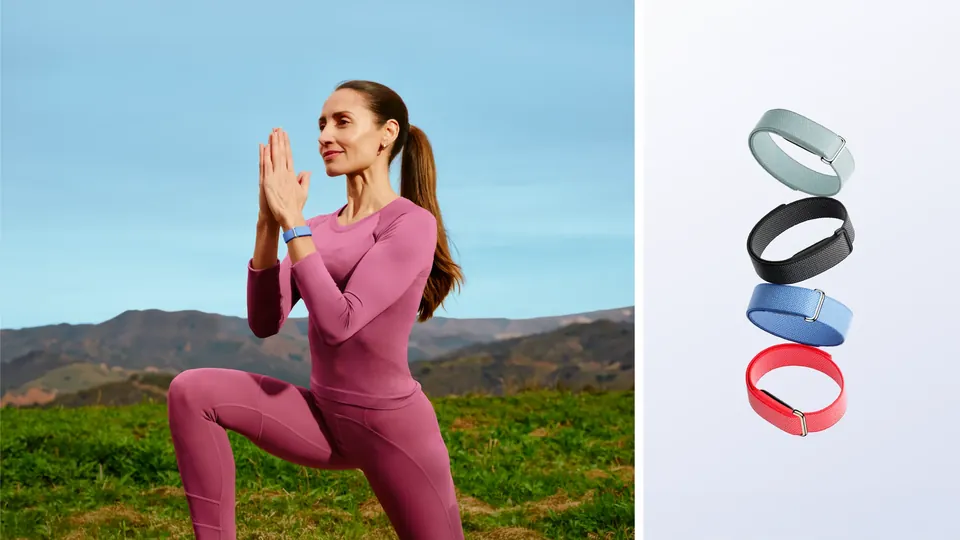 A woman doing a yoga pose outdoors wearing Fitbit Air in a lavender band, next to four loose bands in grey, black, blue and red