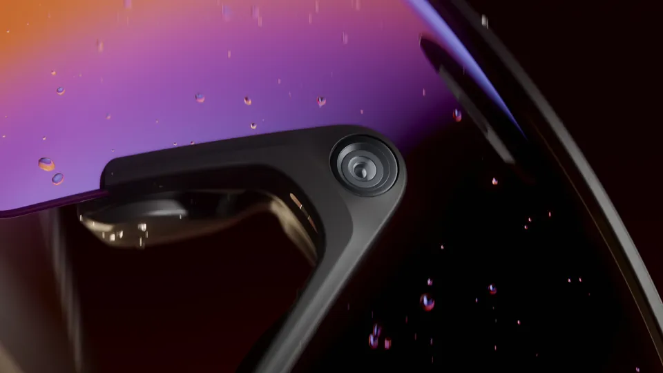 Extreme close-up of the camera mounted at the nose bridge of Oakley Meta Vanguard glasses behind a purple and orange gradient lens speckled with water droplets