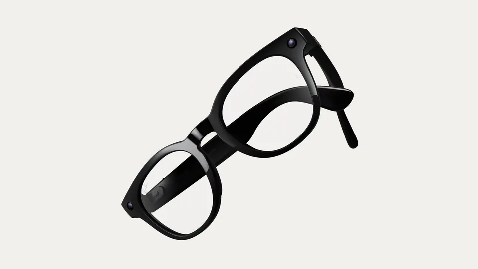 Two pairs of glossy black Ray-Ban Meta glasses with clear lenses, one overlapping the other, floating at an angle on a pale background